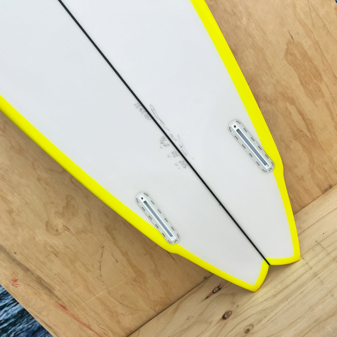 Christenson Lane Splitter 5'10 surfboard with a swallow tail design, featuring a white body with a yellow rail spray. Futures fins, Swallow Tail. Shop Christenson Surfboards at Freeride Surf & Skate NZ