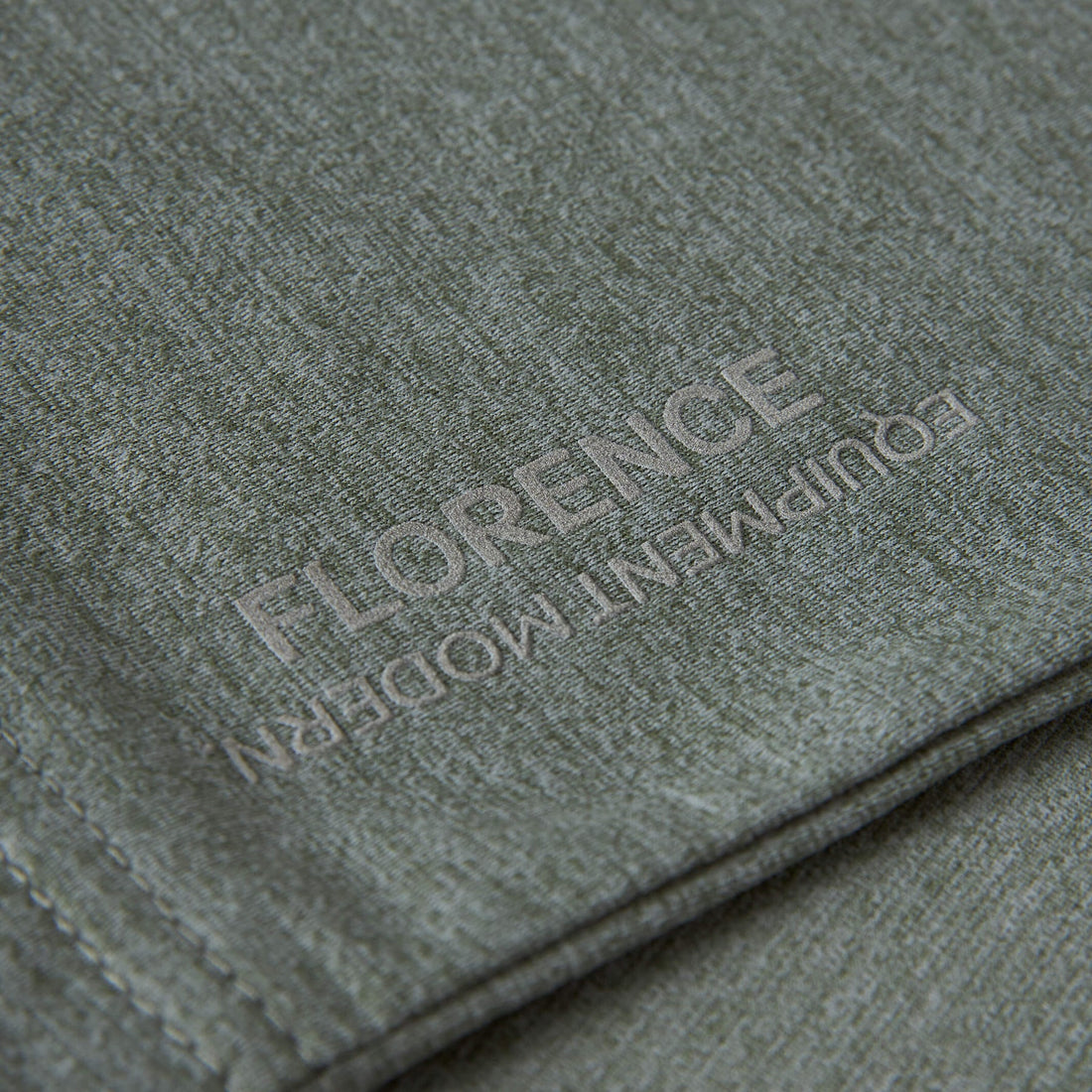 Close-up of Florence Marine X logo detail on Heather Dark Sage Airtex long sleeve hooded shirt