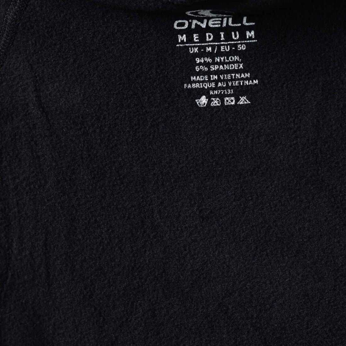 Close-up of a black fabric garment showing the inside neck label with white text reading O'Neill Medium and garment details.